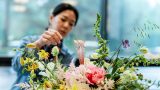 Photo of a woman creating a floral centerpiece