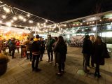 People standing around an outside space with twinkle lights hung at night