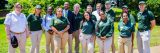 Garden staff wearing green shirts and jackets and khaki pants standing outside in front of grass