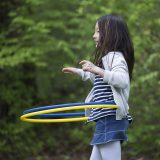 A child playing with two hula hoops.
