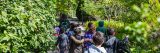 Group of young kids walking through a Garden path with green leaves and bushes