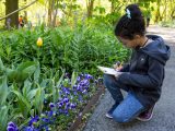 Girl taking notes and studying plants