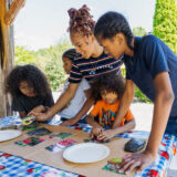 2 adults and 3 children making crafts in Everett Children's Adventure Garden