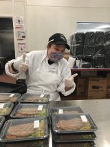 Catie Cuellar, General Manager of the Constellation Culinary Group at The New York Botanical Garden, alongside trays of meals to be donated.