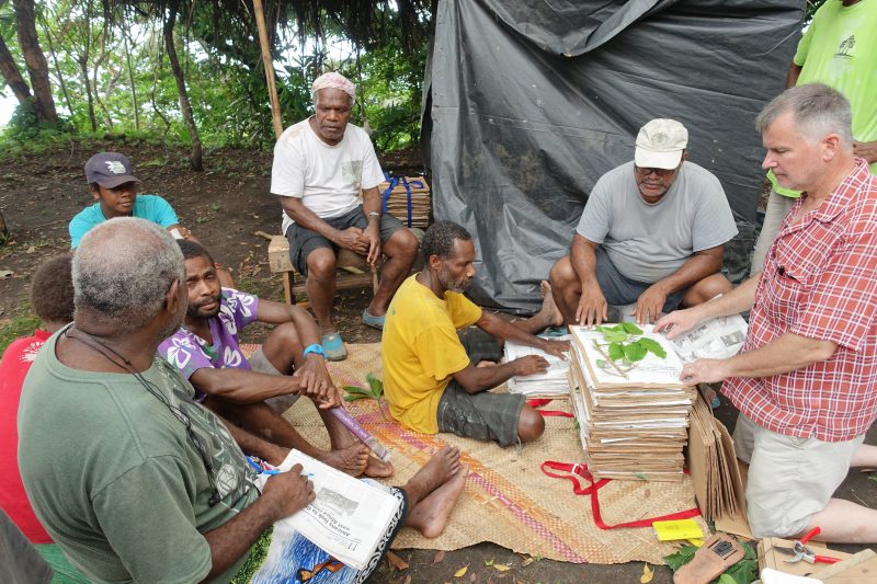 Dr. Gregory Plunkett presses plants with villagers on Tanna island, Vanuatu.