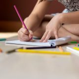 Child drawing with colored pencils