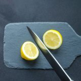 A lemon cut in half on a cutting board