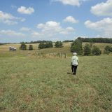 Photo of a woman walking in a field.