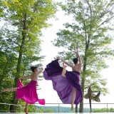Photo of three women performing a dance in nature