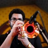 Josh Evans plays a brass trumpet into a microphone