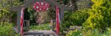 A wooden archway with red and white steamers hanging from it.
