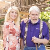 A photo of Laura and Paul Bussee in front of the Holiday Train Show bridge