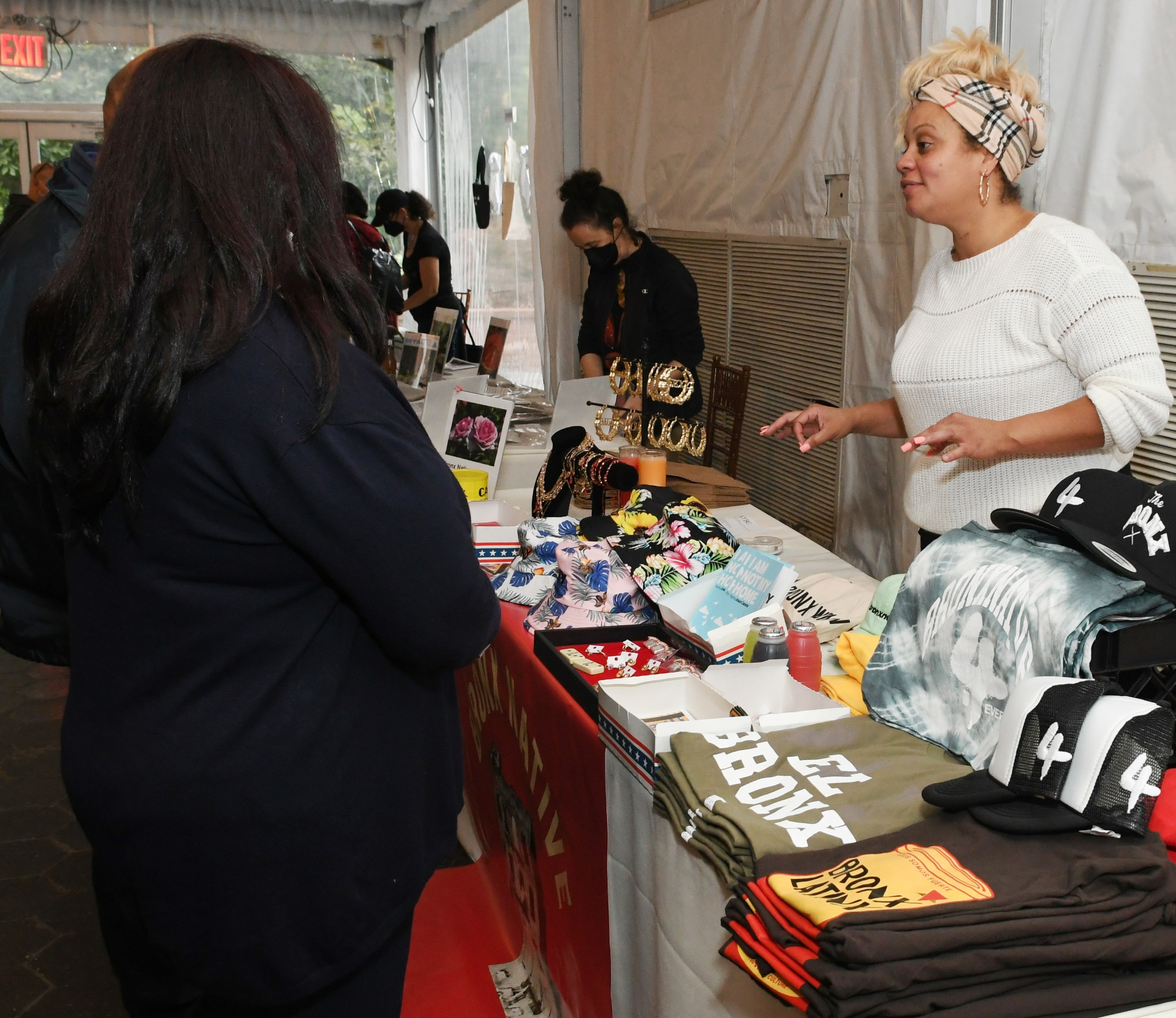 Visitors look over a vendor's table