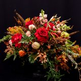 floral arrangement with red roses, fall leaves