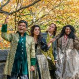 Four actors in the forest dressed as shakesperean characters