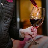 A person pouring wine into a City Winery wine glass