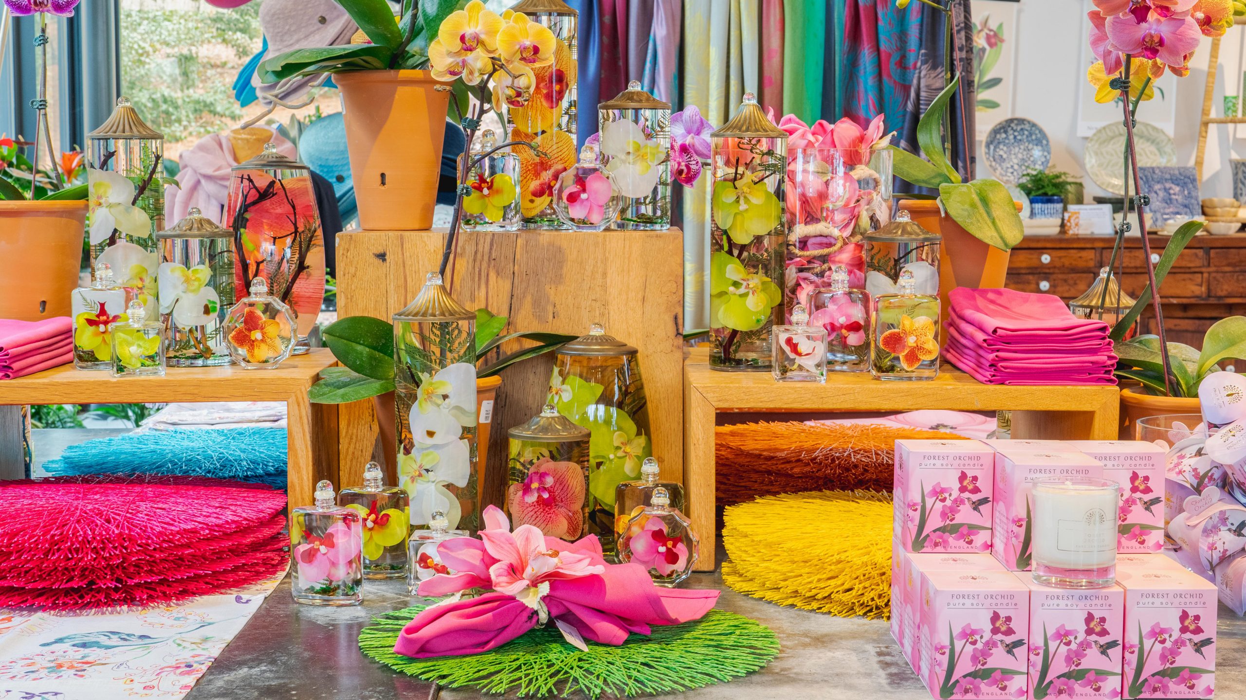 A selection of orchid-themed merchandise in greens, pinks, yellows, and blues