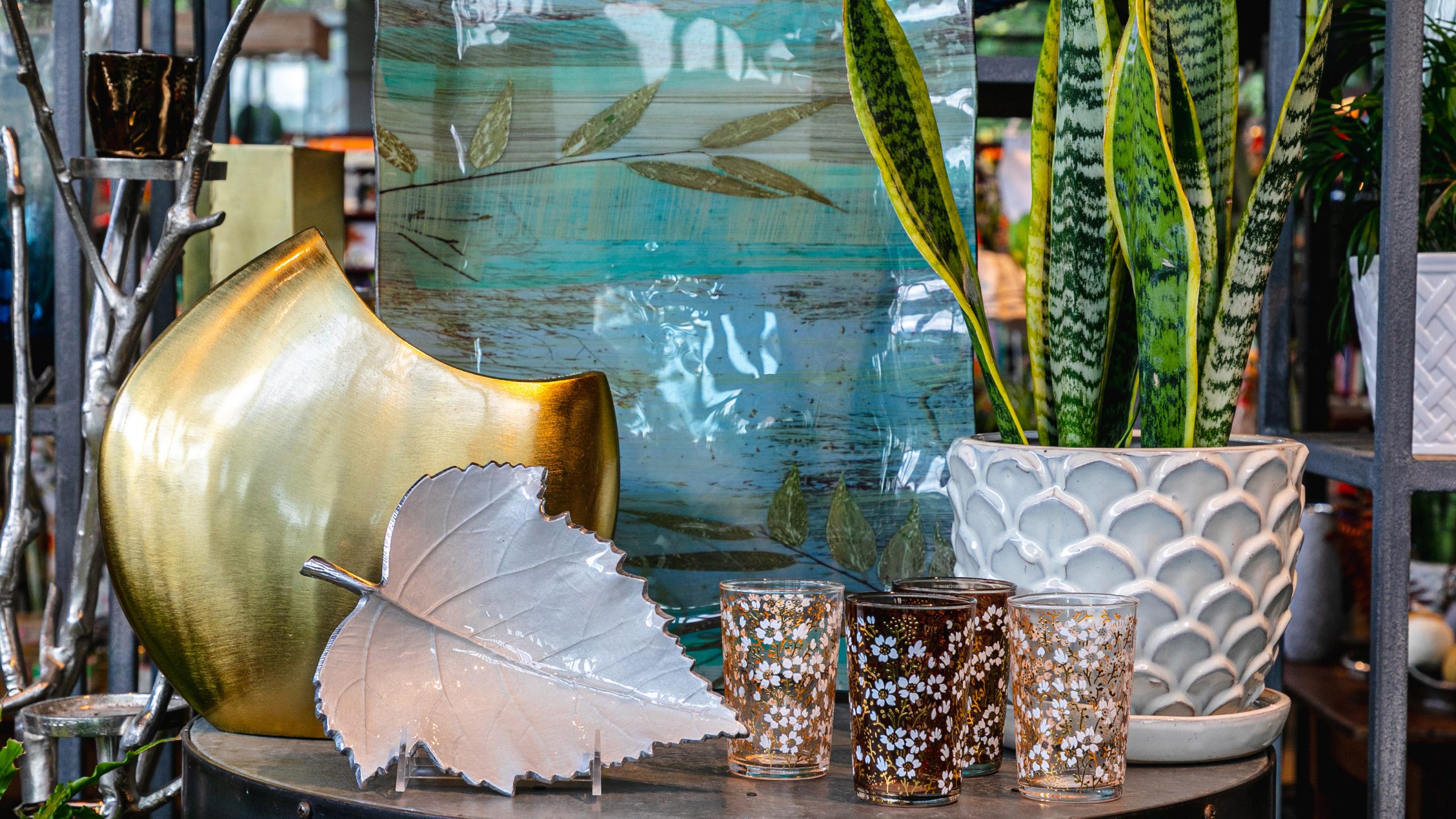 A selection of garden-themed products arranged on a table in greens and golds