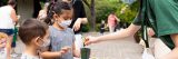 An explainer helping a young child pot a plant