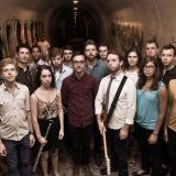 The band Contemporaneous posing in a tunnel with instruments
