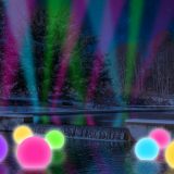 Photo illustration of neon pink, purple, green, yellow, and blue balls on top of water, with neon blue, green, and pink lights shooting up to the sky in the background as a rendering for NYBG GLOW in the Native Plant Garden.