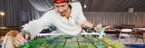 A man in a white shirt and red hat paints a picnic table