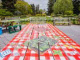picnic table painted with red and white pattern and vegetables