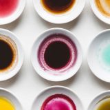 white bowls containing yellow, red, and light blue ink