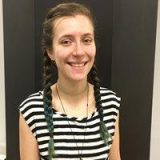 Headshot of Lydia Paradiso, wearing a stripped shirt with braids.