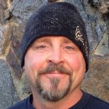 Photo of a man in a black wool hat with a goatee posing for a photo
