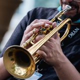 A person plays a brass trumpet