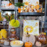 An arrangement of orange, black, green, and yellow Halloween goods and decor arranged on a shop table