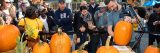 Adam Bierton carving a pumpkin in front of a crowd of people