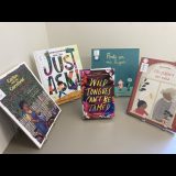 Five books aranged in a semi-cirlce on a grey base.