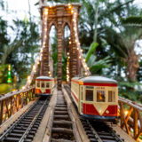 A lit up model of a bridge with two trains driving across it