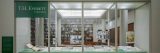 Glass windows with a green sign in the top left corner that says "T.H. Everett: Life in Plants" with rows of books on brown book shelves behind the glass. On green table tops inside the glass displays are small books and other papers facing up.