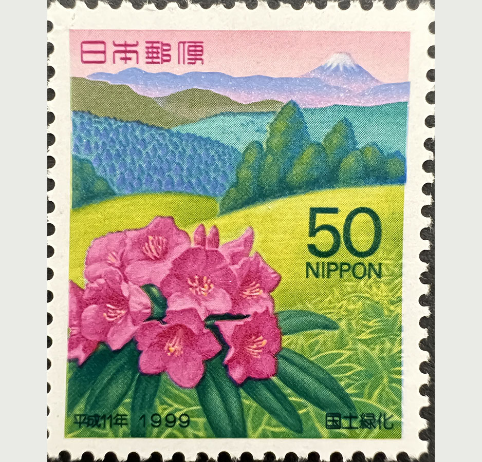 A 50 yen stamp depicting pink flowers blooming on a grassy hill