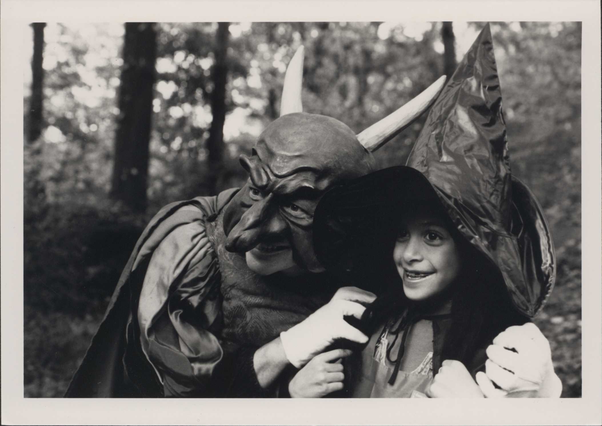 People in witch and devil costumes smile for a photo in black and white