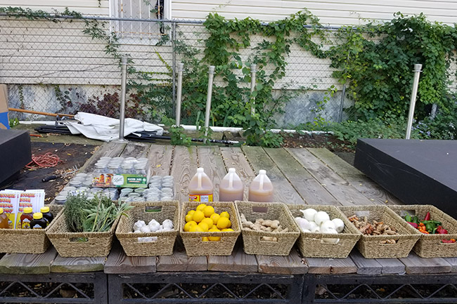 A collection of baskets arranged on an outdoor table, each one full of fruits, vegetables, and other ingredients