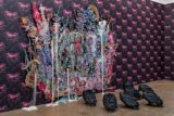 A flock of artistically rendered black birds rests at the base of an artistic collage on the wall of a gallery