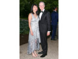 Two people in evening wear pose for a photo after dark