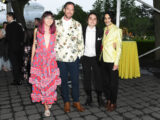 Four people in evening attire pose for a photo outdoors