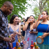 four people enjoying glasses of wine surrounded by green trees