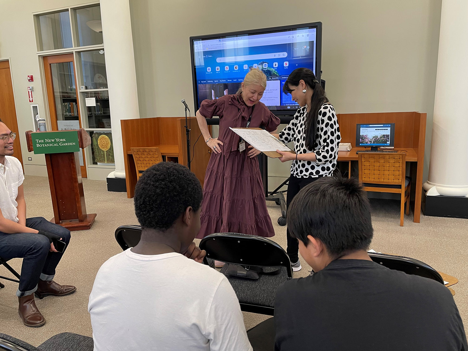 A class of middle school students takes part in a workshop inside a library