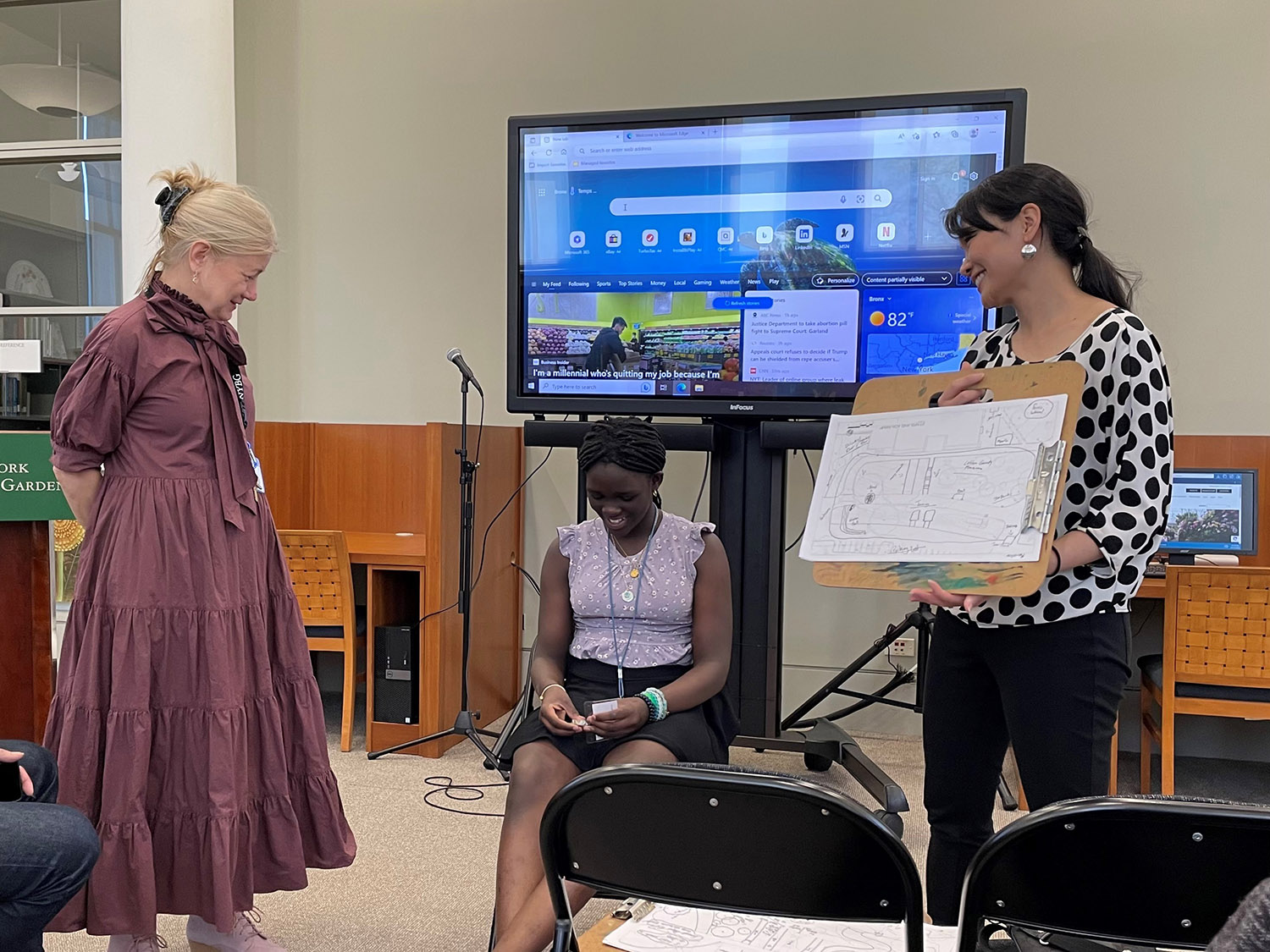 A class of middle school students takes part in a workshop inside a library