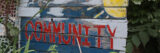 A weathered wooden sign reads "Community" in red and blue paint