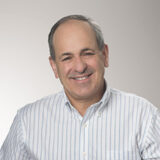 A person in a striped white and blue shirt poses for a headshot