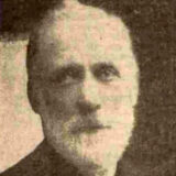 A black and white photo of a person with a white beard