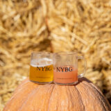 two tiny glasses with "NYBG" printed on them filled with beer, sitting on top of a pumpkin
