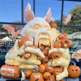 An enormous pumpkin carved into a monstrous sculpture
